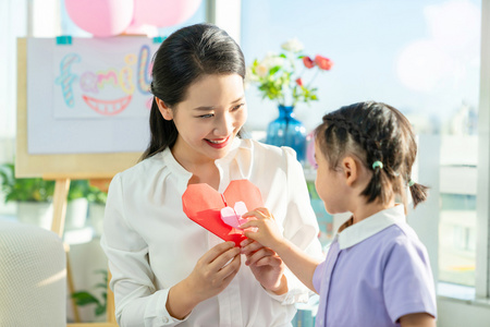 老师和小女孩一起折纸照片