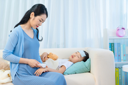 孩子和生病的母亲在头巾牵手和微笑对方母亲照顾生病的女儿母亲照顾