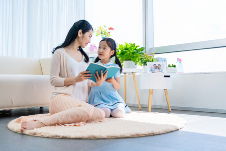 小女孩和妈妈一起看书照片