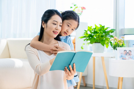 小女孩和妈妈一起看书照片