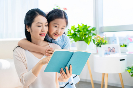 小女孩和妈妈一起看书照片
