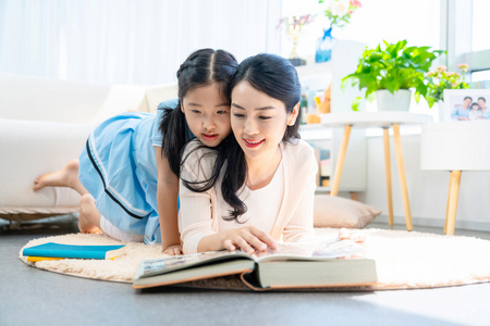 小女孩和妈妈一起看书照片