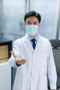 年轻医生戴着口罩在办公室工作照片