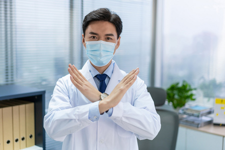 年轻医生戴着口罩在办公室工作照片