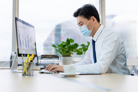 戴着口罩在办公室工作年轻商务男士戴着口罩办公女人戴口罩在医院的
