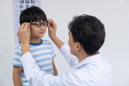 视力表的卡通眼睛球眼镜考试与眼科医生眼科大夫给小男孩检查眼睛眼科