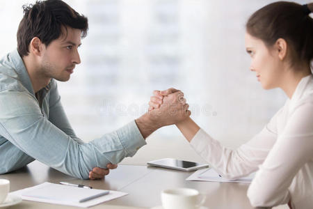 女性的和男性的商业竞争对手摔跤,对抗的为领导照片