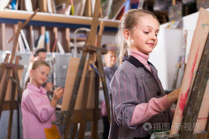 年幼的女孩开业的他们的技能在的时候绘画