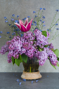 富有色彩的花束采用玻璃装饰瓶和紫色的丁香花属,p采用k郁金香和照片