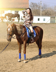 年幼的漂亮的黑头发的妇女骑马马户外的照片