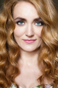 弯曲的长美丽的年幼的女人和长的红色的弯曲的头发照片