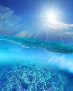 天海珊瑚礁在下面深的蓝色海水和太阳光亮的越过天照片