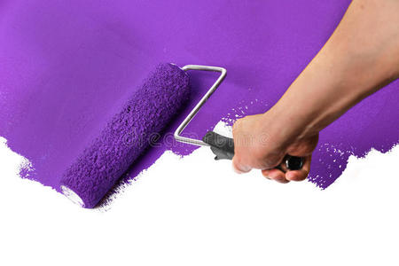 男人,用白漆和油漆辊或刷子刷墙.