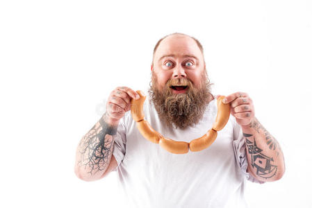 幸福的肥的男人吃肉和享受照片