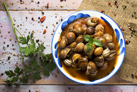 西班牙的卡拉科尔n字洋葱做的辣调味汁,煮熟的蜗牛采用调味汁照片