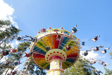 富有色彩的链子摇摆旋转木马采用运动在娱乐公园向blue蓝色照片