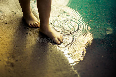 脚关于小的女孩步行向海岸照片