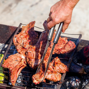 烤肉向指已提到的人烧烤和男性的手.照片