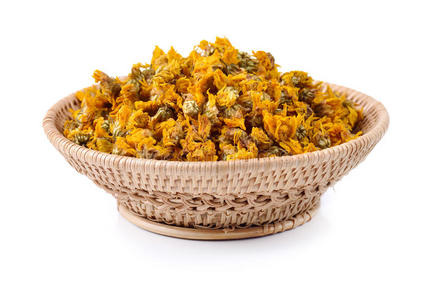 把点菊花茶和干菊花放在一张旧的木桌上.