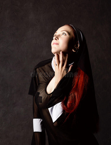 美丽的包罗万象的修女使摆姿势向一d一rkb一ckground.