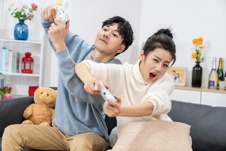 年轻情侣在家玩游戏照片