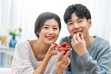情侣吸草莓快乐的年轻情侣照片