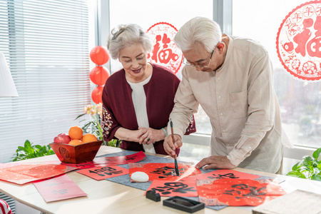 快乐的老年夫妻在家写毛笔字