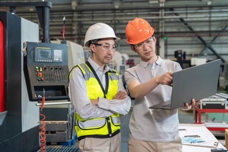 工厂工作服两个工程师穿保护工作服戴着安全帽在工厂工作照片