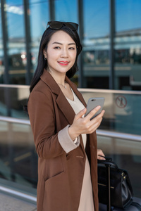 商务女士在机场使用手机