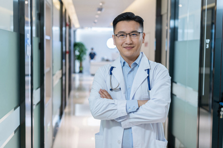 男学生站着双臂交叉在大学礼堂图片