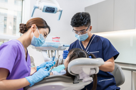 防护镜医生牙科医生给小女孩治疗照片