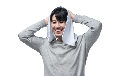 年轻男子在用毛巾擦头发照片