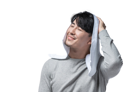 年轻男子在用毛巾擦头发照片