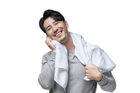 年轻男子在用毛巾擦头发照片