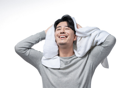 年轻男子在用毛巾擦头发照片