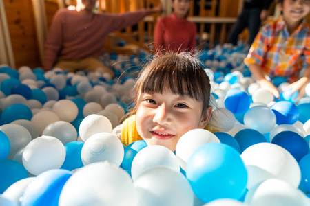 快乐的小女孩在玩海洋球照片