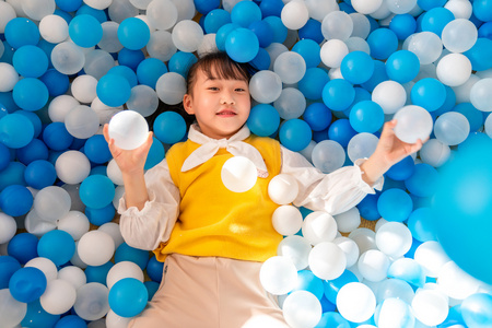 快乐的小女孩在玩海洋球照片