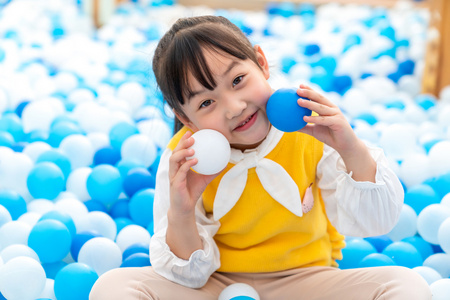 快乐的小女孩在玩海洋球照片