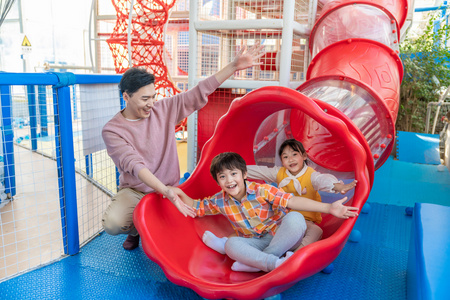 父子游乐园一家人在玩滑梯照片