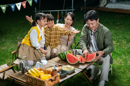 傍晚一家人在露营地吃西瓜照片
