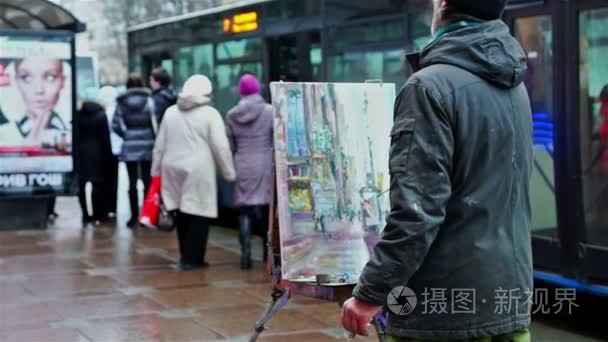 艺术家画在公共汽车站附近的街视频