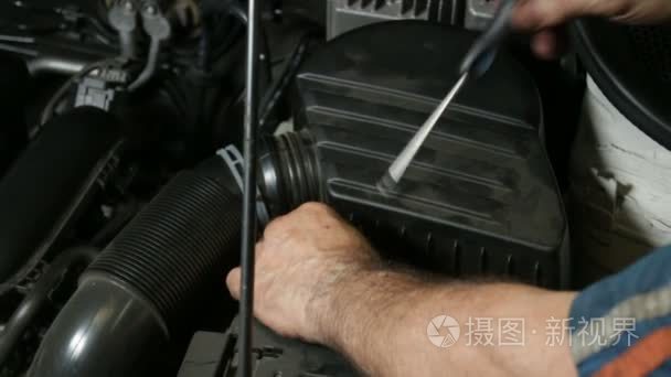 Mechanic Screwing Automobile Air Filter.