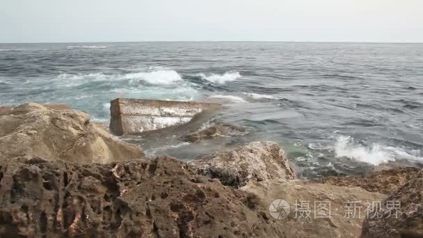 在岩石上的浪花的波浪视频