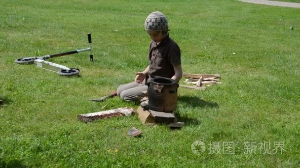 小男孩劈木柴和准备火地方视频