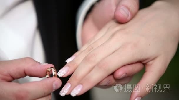 A man puts his woman a wedding ring on the finger. Close up macr
