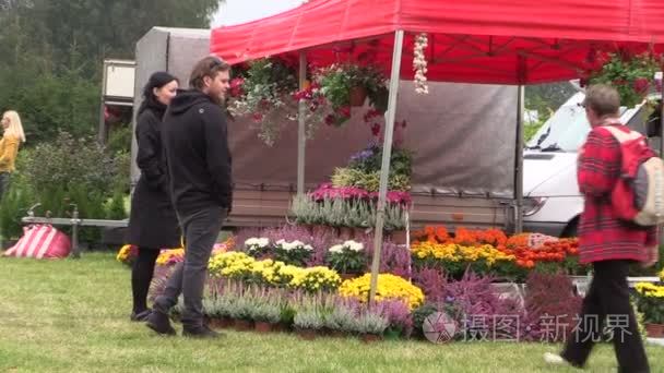 人们买鲜花和植物在植物节公平视频