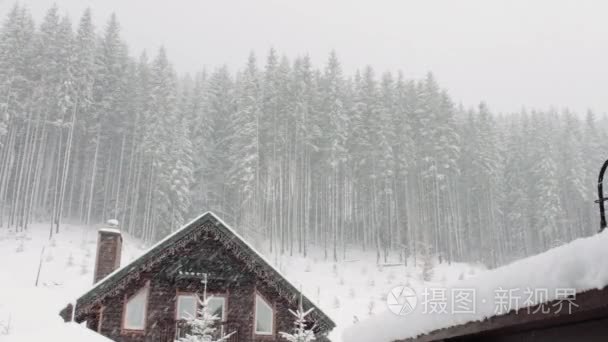 强降雪将于背景的圣诞树和木房子里