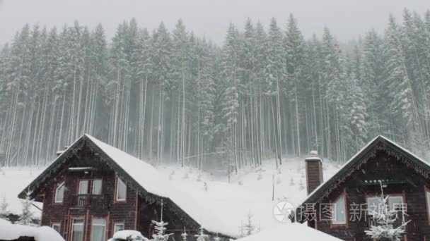 强降雪将于背景的圣诞树和木房子里