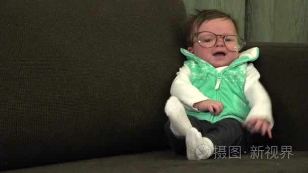 婴儿坐在沙发上与眼镜视频