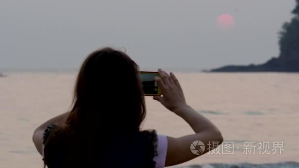 女孩拍摄橘黄色的夕阳剪影视频